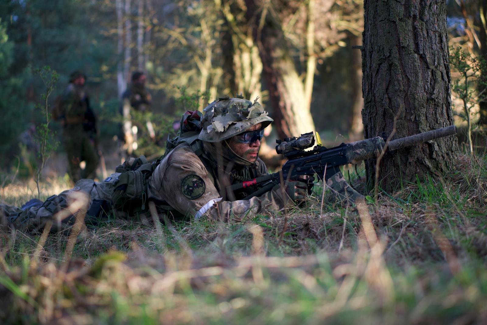 Soldier on a mission in camouflaged gear with a rifle during a forest training mission, focusing on stealth and strategy.